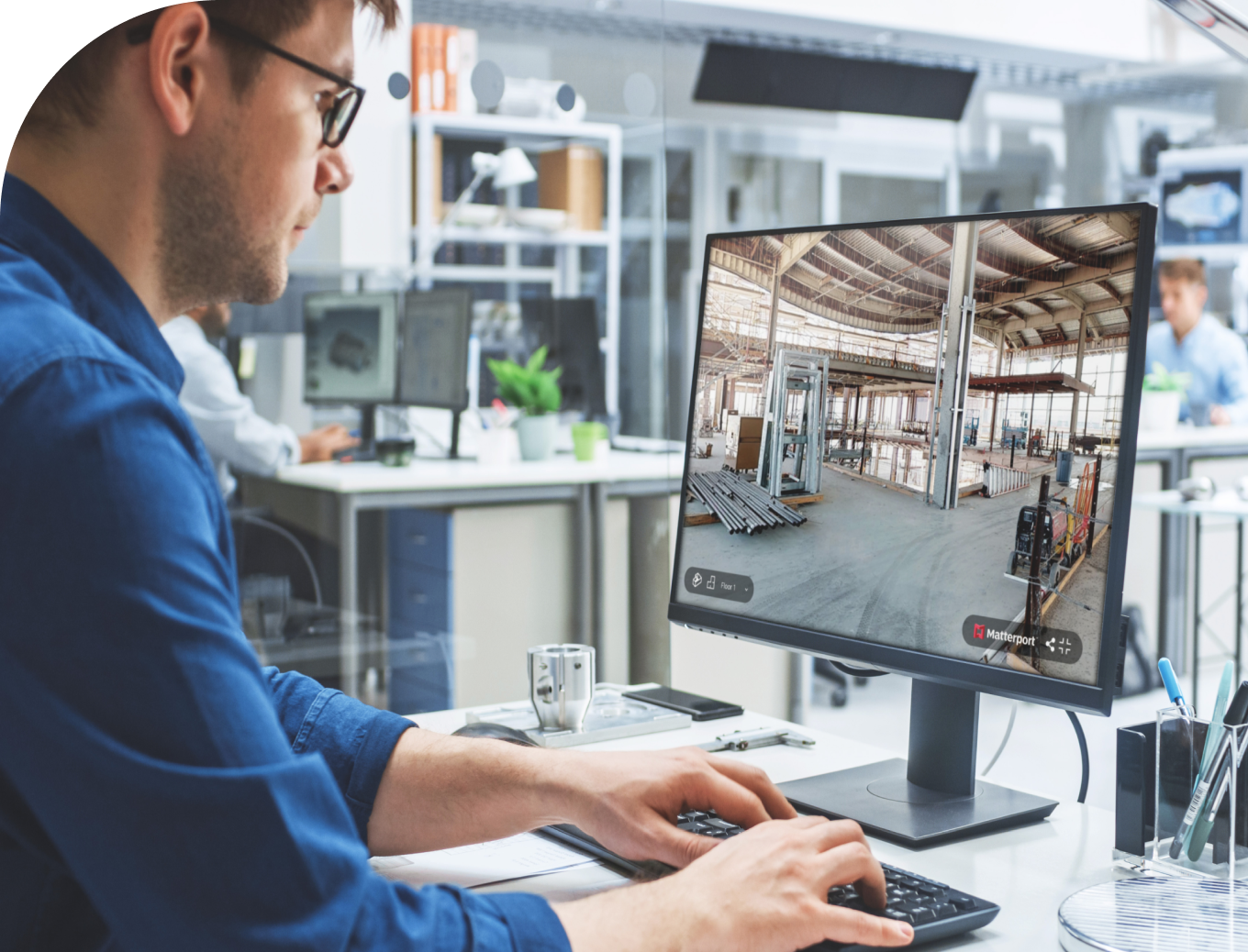 A man sitting at a computer working on a Matterport model