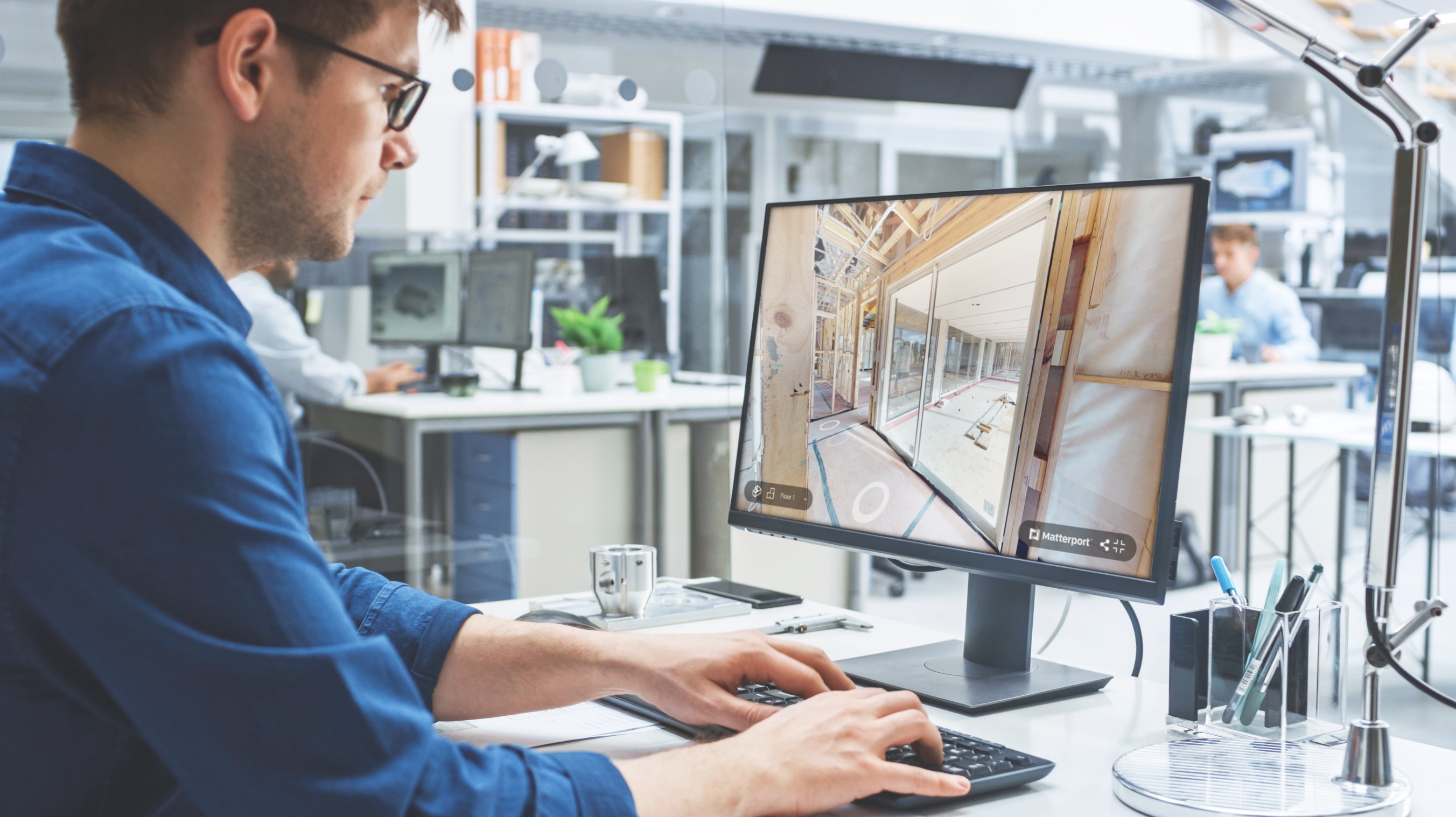 A man sitting at a computer working on a Matterport model