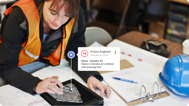 A woman in the AEC industry wearing safety equipment and using a laptop with a Matterport model on the screen